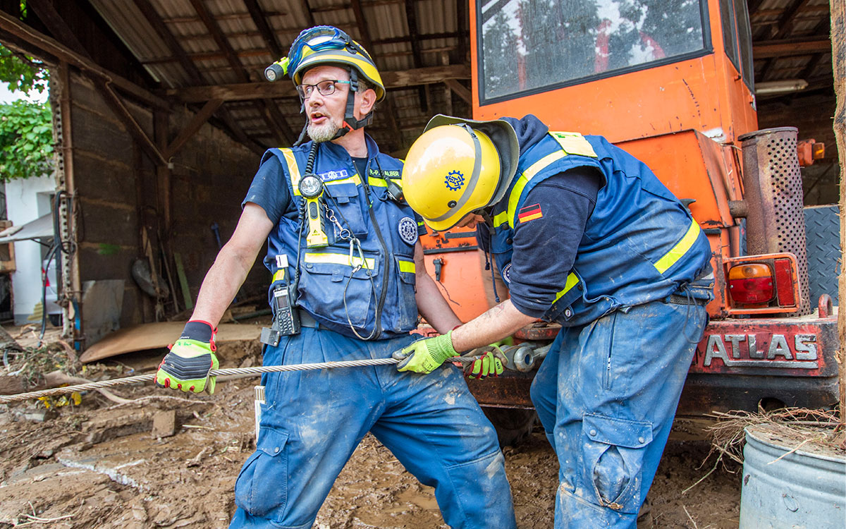 Nach dem Wasser beginnt das Aufräumen. Mit schwerem Gerät legen die Einsatzkräfte Zufahrtswege und Straßen wieder frei.<br>Quelle: THW/Florian Pelz